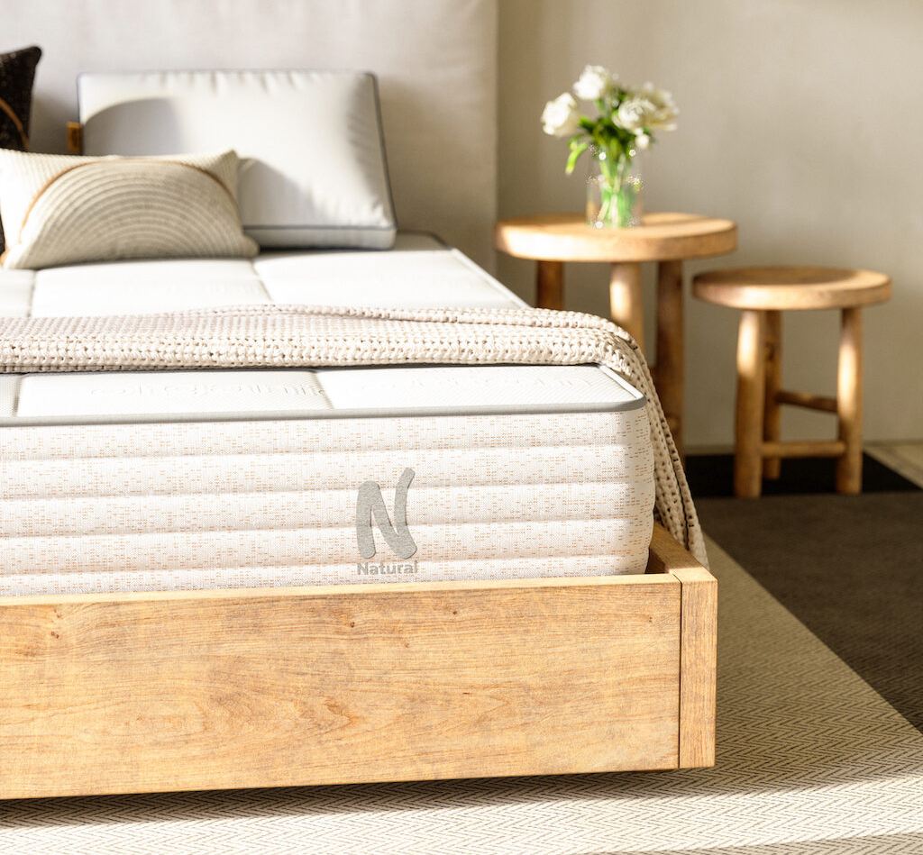 corner view of the nolah natural latex mattress showing the quilted pillow top and the channel quilted side fabric of the mattress