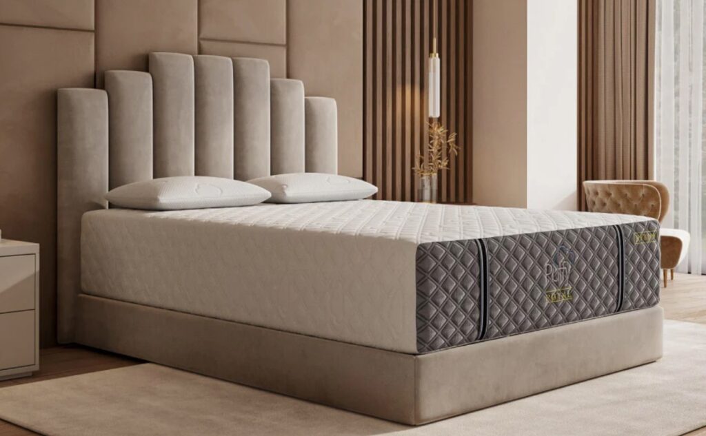 puffy royal mattress review photo shows puffy royal mattress in a sweeping contemporary bedroom with a velvet headboard. the photo showcases the royal mattresses outer quilted covering
