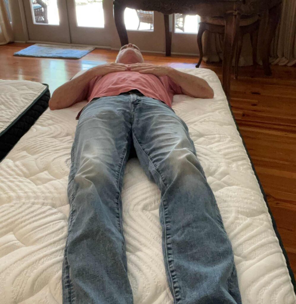 Marc is lying on his back of The Logan And Cove mattress to illustrate good back support and even weight distribution.